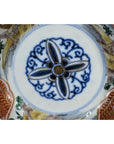 Close-up of antique hand painted Japanese Imari porcelain bowl with blue floral and red fish design inside.