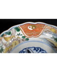 Close-up of an antique hand painted Japanese Imari porcelain bowl with vibrant traditional patterns on the rim.