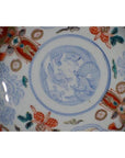 Close-up of blue, red, and gold hand painted Japanese Imari porcelain bowl with floral and animal motifs.
