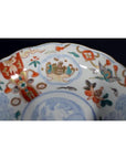 Close-up of antique Japanese Imari porcelain bowl with hand painted red, blue, and gold floral patterns.