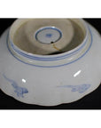 Multicolor porcelain bowl upside down, hand painted with Imari design, set against a black background.
