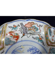 Close-up of a red, blue, green, and gold porcelain Japanese Imari bowl with crane and floral patterns.