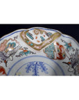 Close-up of blue, red, green, and gold Imari porcelain bowl with floral and bird motifs, antique hand-painted design.