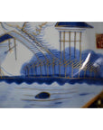 Close-up of blue and white hand painted porcelain Japanese Imari plate featuring a landscape design.