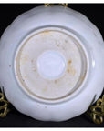 Close-up of the underside of an antique hand painted Japanese Imari porcelain plate with stains on a gold stand.