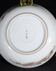 Close-up of the underside of an antique hand painted Japanese Kutani porcelain plate on a gold stand.