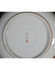 Close-up of the base of an antique hand painted Japanese Kutani porcelain plate with red Japanese characters in center.