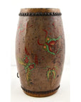 Brown wood and leather drum with hand painted floral designs, raised dots on top and middle, barrel shaped, close-up.