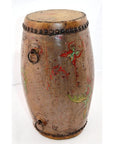 Close-up of antique hand-painted wood and leather drum with metal rings, red and green floral side designs.