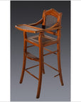 Dark wood and rattan antique highchair with tray and footrest, displayed against a plain dark background.