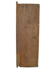 Brown antique Indian wooden door with iron hardware against plain white background.