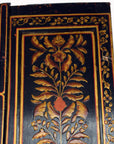 Black and gold lacquered wooden door with intricate floral carvings, antique style.