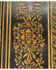 Black lacquered wooden door with gold and brown floral motifs, ornate patterned surface.