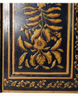 Close-up of black lacquered wooden door with gold floral motifs, antique Indian style.
