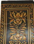 Brown and gold lacquered wooden door with ornate floral motifs and a wire for hanging at the top.