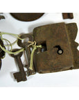 Close-up of an antique metal Indian lock with original keys tied by string, displayed on a white surface.
