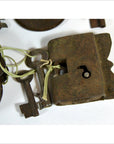 Close-up of an antique metal Indian lock with original keys tied by string, displayed on a white surface.