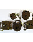 Close-up of five antique brass Indian locks with original keys displayed on a white background.