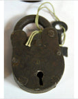 Close-up of antique metal Indian lock with key tied on string, displayed on white background.
