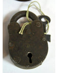 Close-up of antique metal Indian lock with key tied on string, displayed on white background.