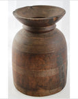 Close-up of brown wooden antique Indian milk storage container with etched lines and wide flared opening.
