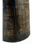 Close-up of a brown antique Indian milk storage container, cylindrical with carved horizontal and vertical lines.