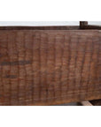 Brown wood planter close-up with weathered, chiseled finish and visible grain.