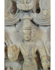 Brown sheesham wood carving of Shiva holding a book, ornate headdress and jewelry, detailed Indian design.