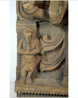 Brown Sheesham wood carving of small praying figure beside larger draped figure, Indian antique style, close-up.