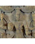 Brown Sheesham wood carving, close-up of a multi-armed deity with jewelry, headdress, and symbolic objects.