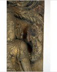 Close-up of brown Sheesham wood carving, antique Indian art with weathered torso and raised hand detail.