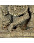 Close-up of brown Sheesham wood carved lower legs and feet in intricate antique Indian attire.