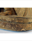 Close-up of brown sheesham wood carving base with intricate patterns and chipped edge.