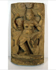 Brown Sheesham wood carving of an antique Indian dancing female deity with ornate jewelry and clothing, close-up view.