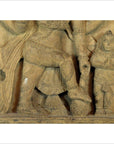 Brown Sheesham wood carving, large figure stepping on smaller praying figure, intricate traditional details, close-up.