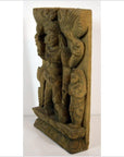 Brown Sheesham wood carving of a standing Indian deity, intricate details on rectangular panel, close-up view.