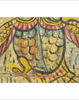Close-up of colorful hand-painted bird wings and feathers on antique Indian wood shrine in yellow, orange, and black.