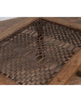 Brown wooden side table with window grate top and turned baluster legs on wood floor, indoors.