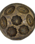 Brown wooden antique Indonesian cake mold with three oval and three flower-shaped compartments, top view.