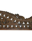 Brown wood Indonesian wall carving with ornate floral and leaf patterns, intricate cutouts along the bottom edge.