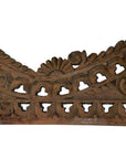 Brown wood Indonesian wall carving with intricate floral scroll patterns, geometric cutouts, and rustic finish, close-up.