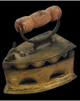 Brass coal iron with wood handle, vent holes, and latched lid on display as vintage décor.