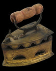 Brass coal iron with wood handle, vent holes, and latched lid on display as vintage décor.