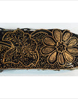 Close-up of black fabric with gold floral motifs, created using an antique Indonesian batik stamp block.