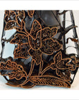 Close-up of antique copper Indonesian batik ink block with detailed floral and leaf patterns for textile printing.