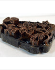 Copper batik ink block with intricate hand-carved floral patterns, antique Indonesian design, close-up view.