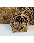 Close-up of three antique copper batik ink blocks with intricate floral and leaf carvings, Indonesian textile tools.