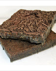 Copper batik ink blocks, antique Indonesian set of 3, intricately carved, for fabric or paper printing, on table.