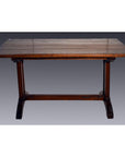 Rectangular teakwood antique Indonesian dining table with sturdy legs, set against a plain gray background.