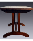 Brown teakwood dining table with thick plank top and sturdy curved legs, shown from the side.